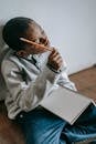 Pensive black kid with notepad and pencil