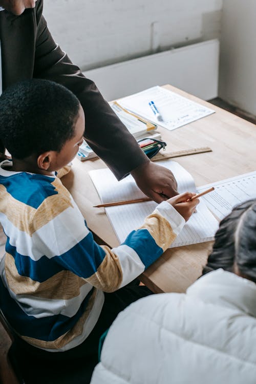 Smart kids studying with teacher in classroom