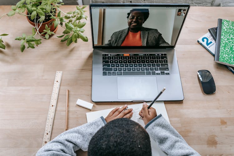 Black Teacher On Laptop Screen During Lesson With Crop Schoolboy