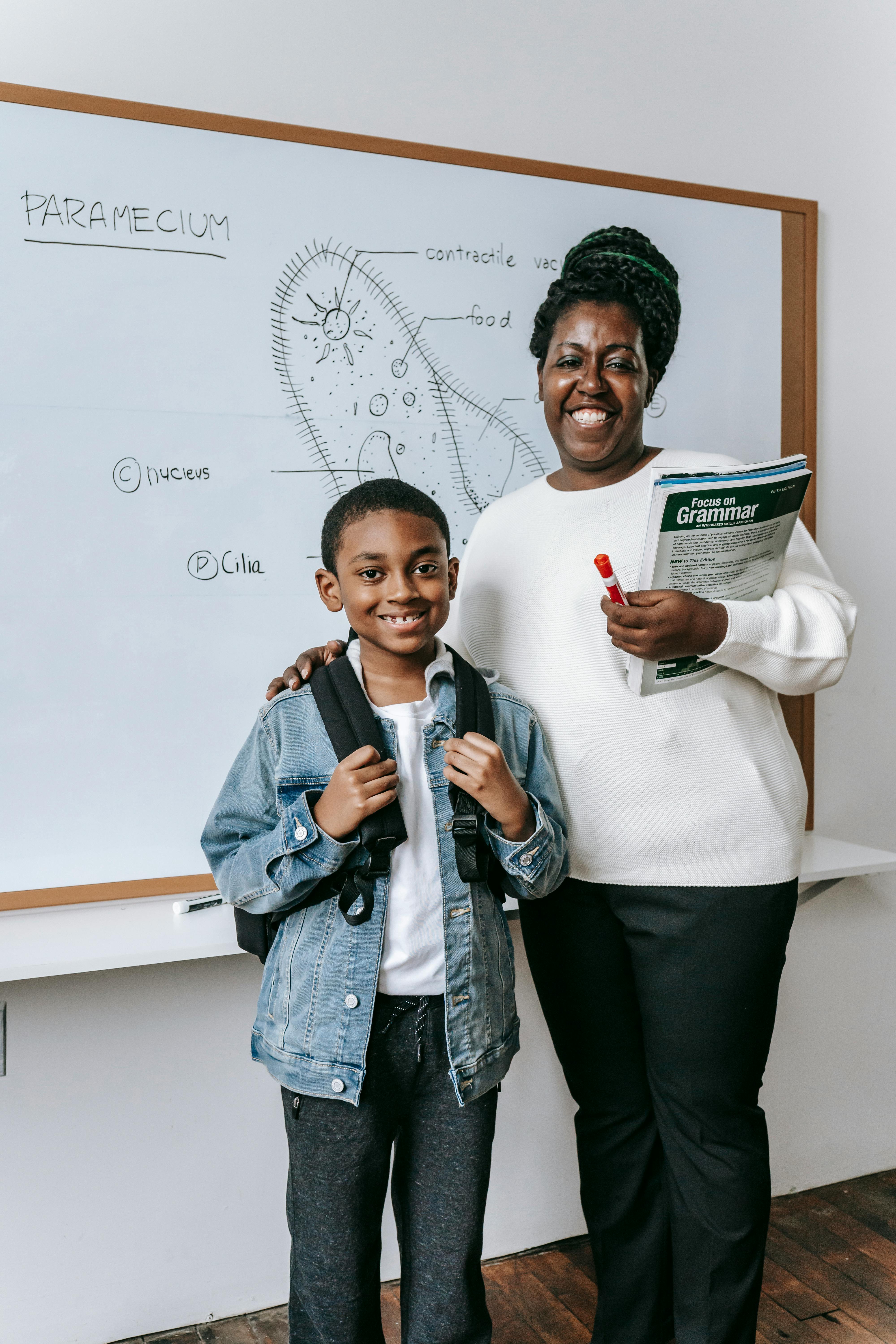 happy black woman with pupil in classroom