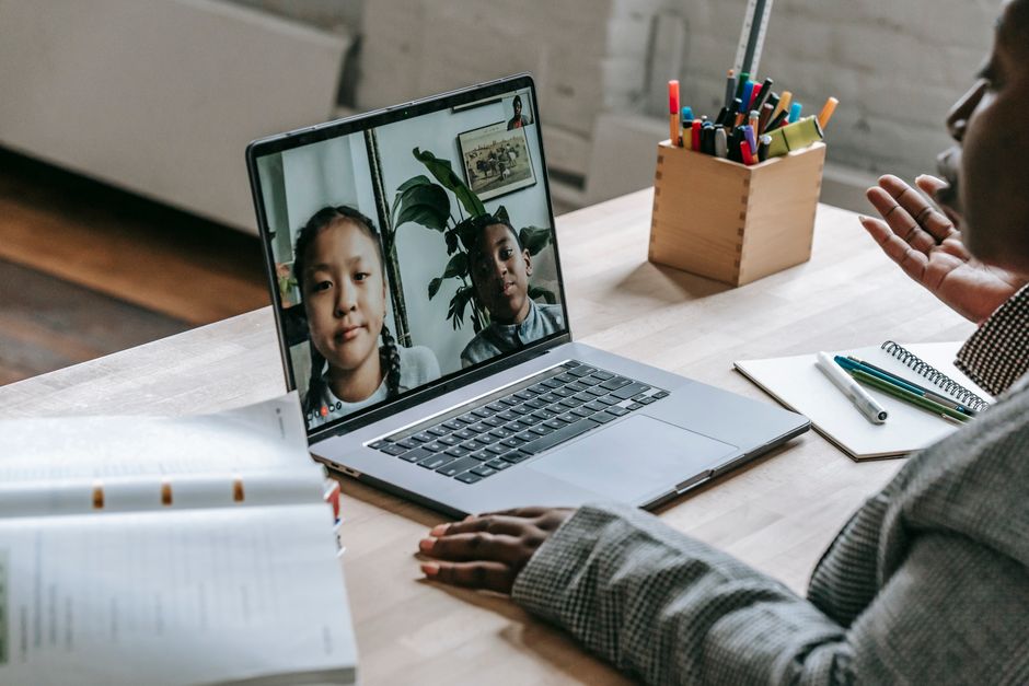 Teacher connecting with students online during a video call