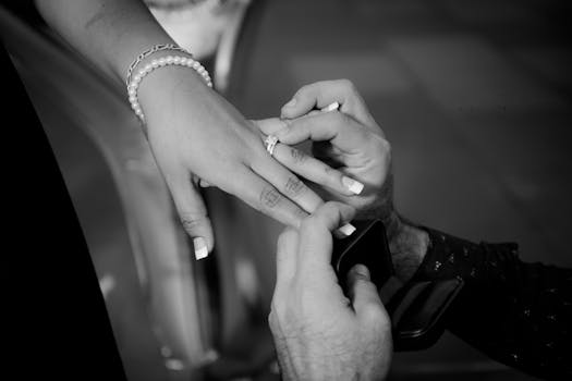 Close-up of a romantic proposal with an elegant engagement ring in monochrome.