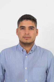 Portrait of a confident man in a blue shirt against a white background.