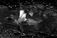 Black and white closeup of abstract background representing dry inorganic material with rough uneven surface