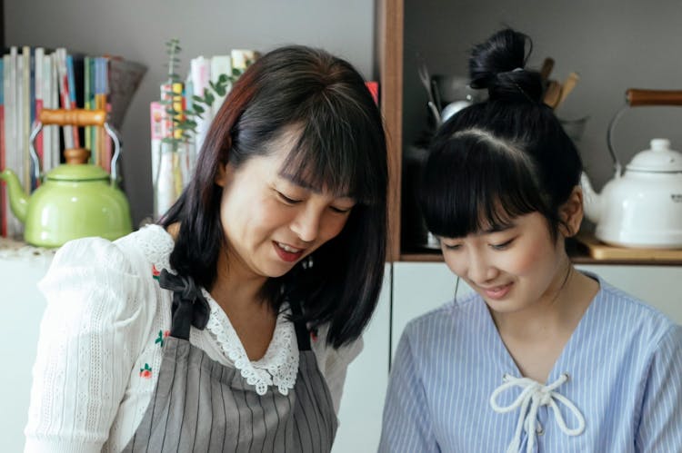 Cheerful Asian Mother And Daughter Cooking Together In Kitchen