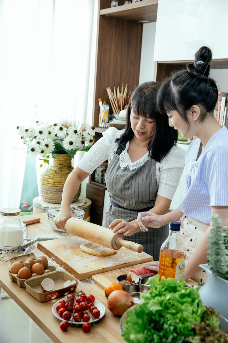 Asian Women Making Dough In Kitchen