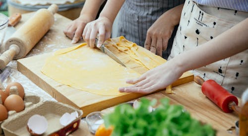 Women making homemade pasta in kitchen
