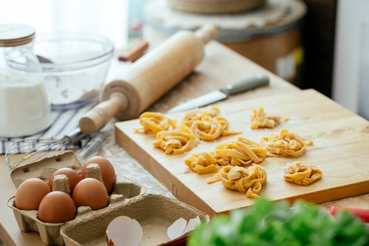 Piles Of Homemade Pasta On Wooden Board