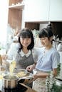 Young Asian women cooking together in kitchen