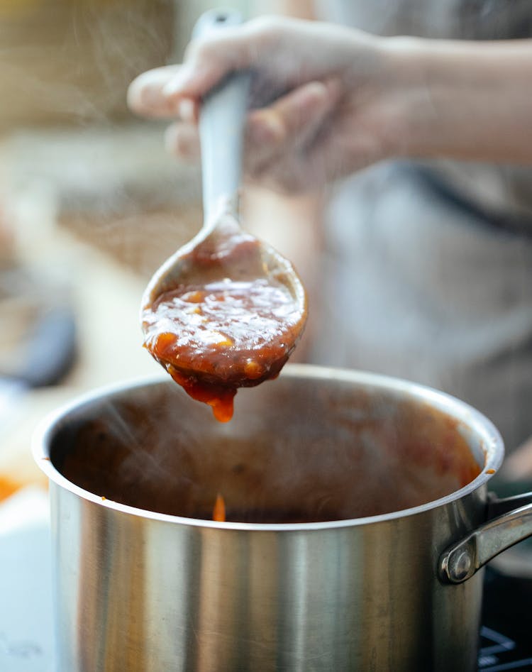 Crop Person With Spoon Near Pan