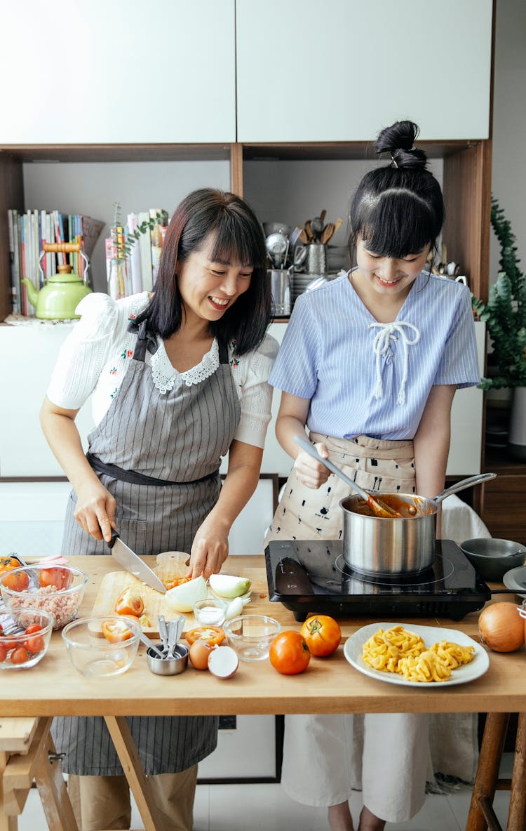 Cheerful Asian Women Preparing Food In Kitchen