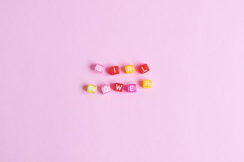 Free Colorful letter blocks spelling 'Girl Power' on a pink background, emphasizing empowerment. Stock Photo