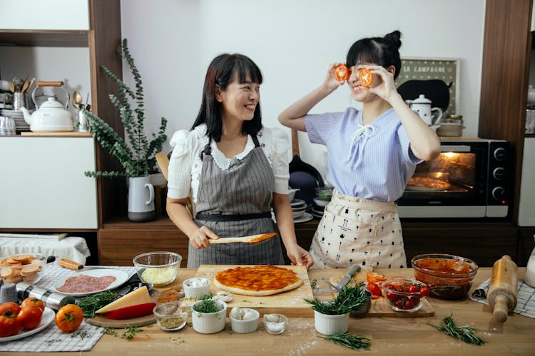 Positive Women Having Fun Cooking Pizza