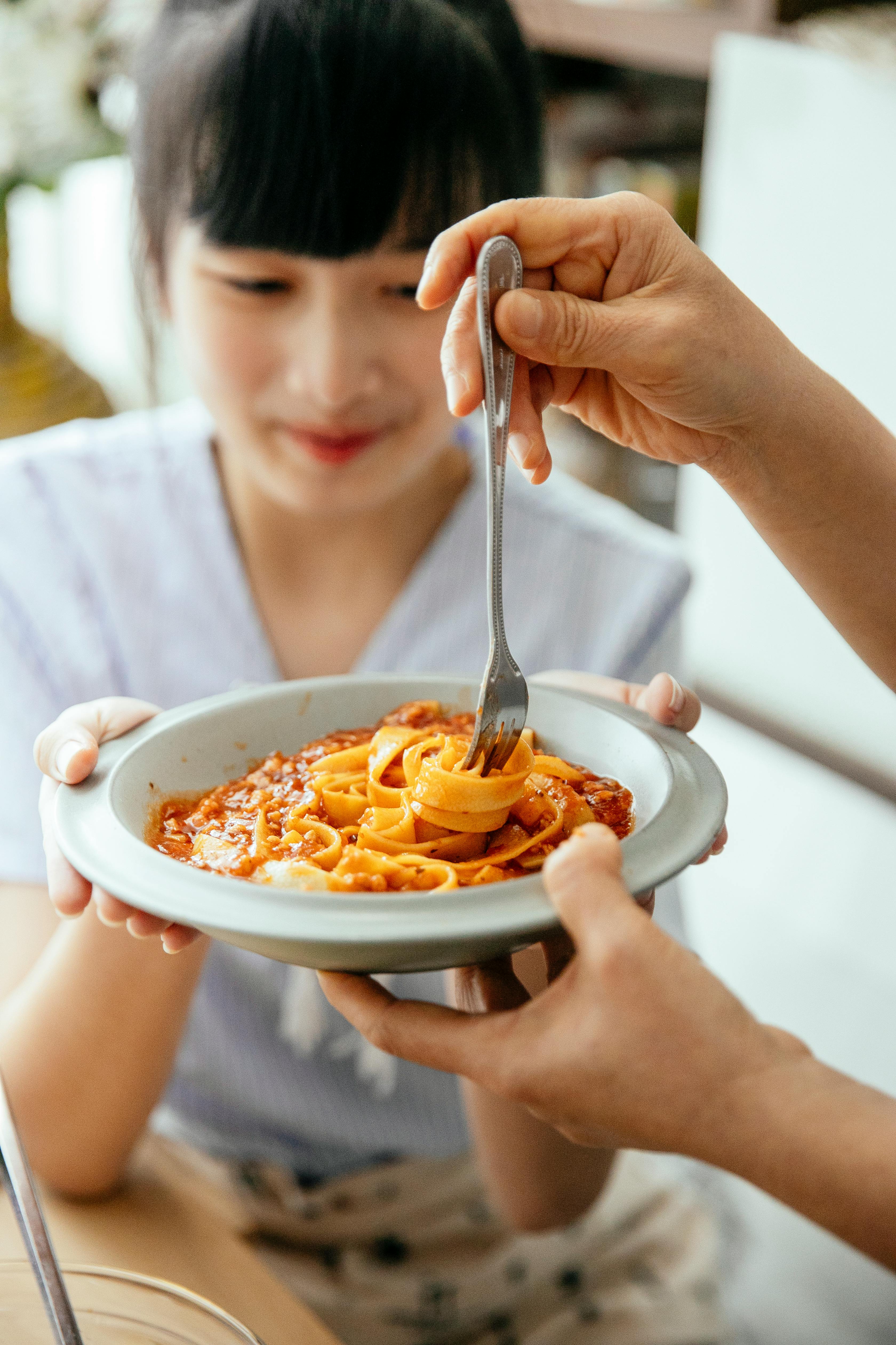 asian women tasting pasta together