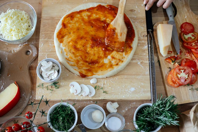 Process Of Preparing Pizza On Table With Fresh Ingredients