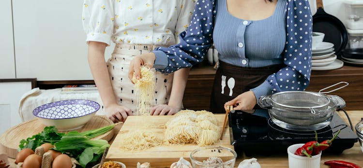 Women Cooking Pasta On Kitchen Together