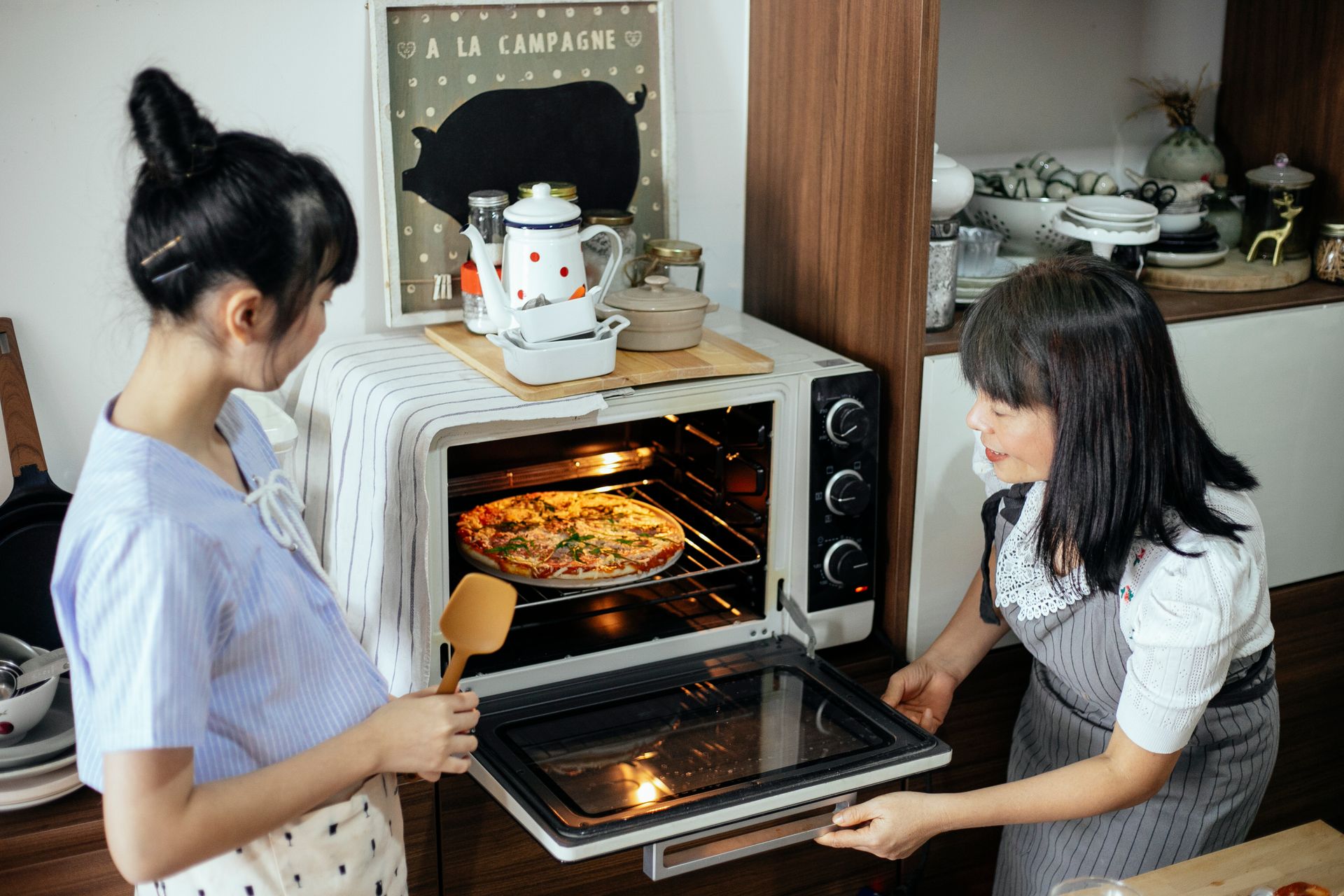 Women Cooking Pizza in an Oven