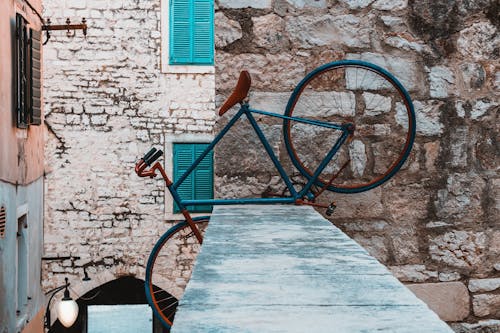 Blue Bicycle on Top of Concrete Fence