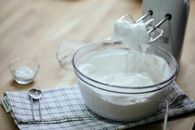 Composition on bowl with delicious whipped cream near mixer