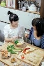 Cheerful Asian women eating tasty ramen soup and chatting