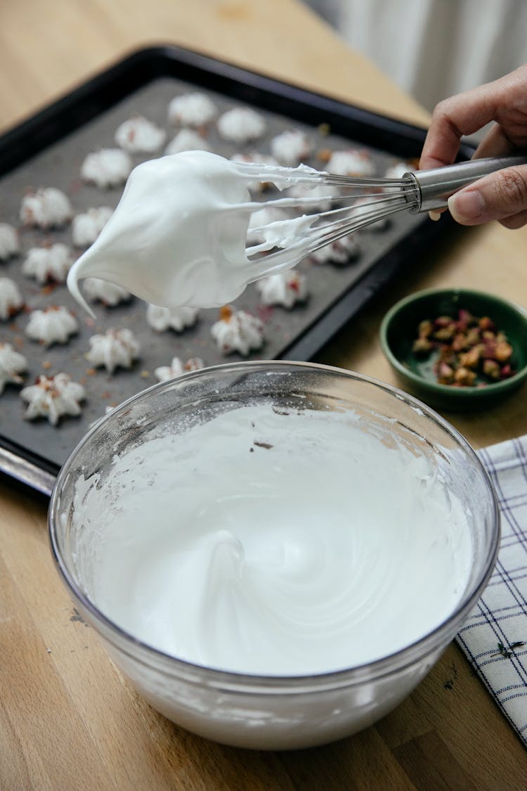 Crop Woman With Whipped Egg Whites On Whisk