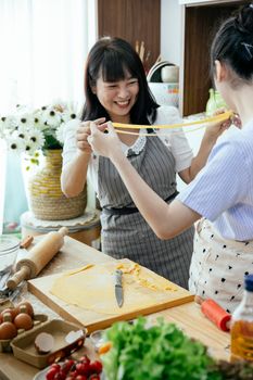 女士们在家庭厨房里快乐地制作新鲜的意大利面，一起享受烹饪过程