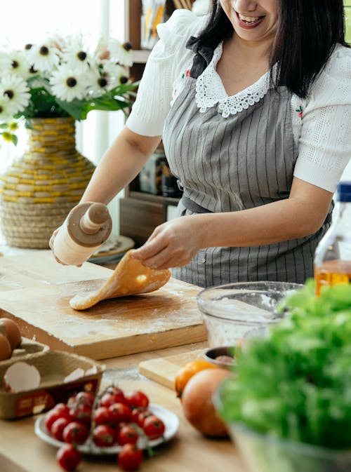 빵을 자르는 흰색과 회색 줄무늬 셔츠에 여자