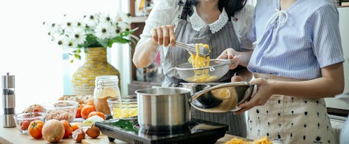 Free Crop women cooking pasta in kitchen Stock Photo