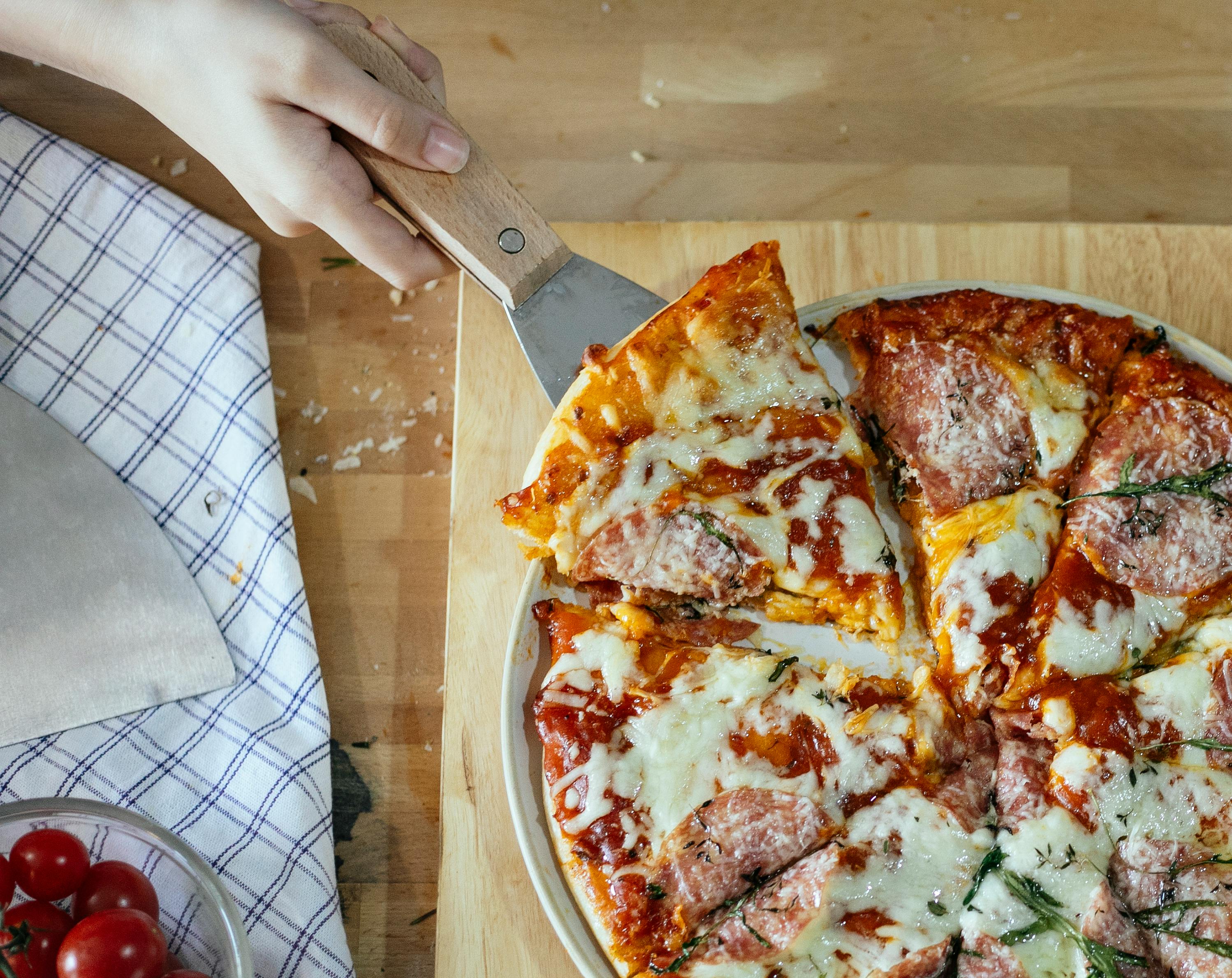 crop woman taking slice of pizza