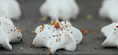 Free Closeup of uncooked white meringue dessert with mix of dry spices on top on baking pan Stock Photo