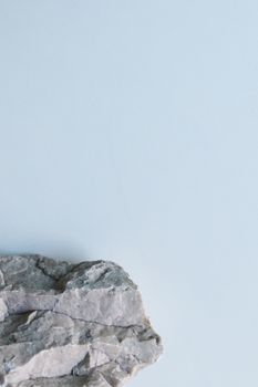 Minimalist photo of a textured rock against a plain white background for design use.