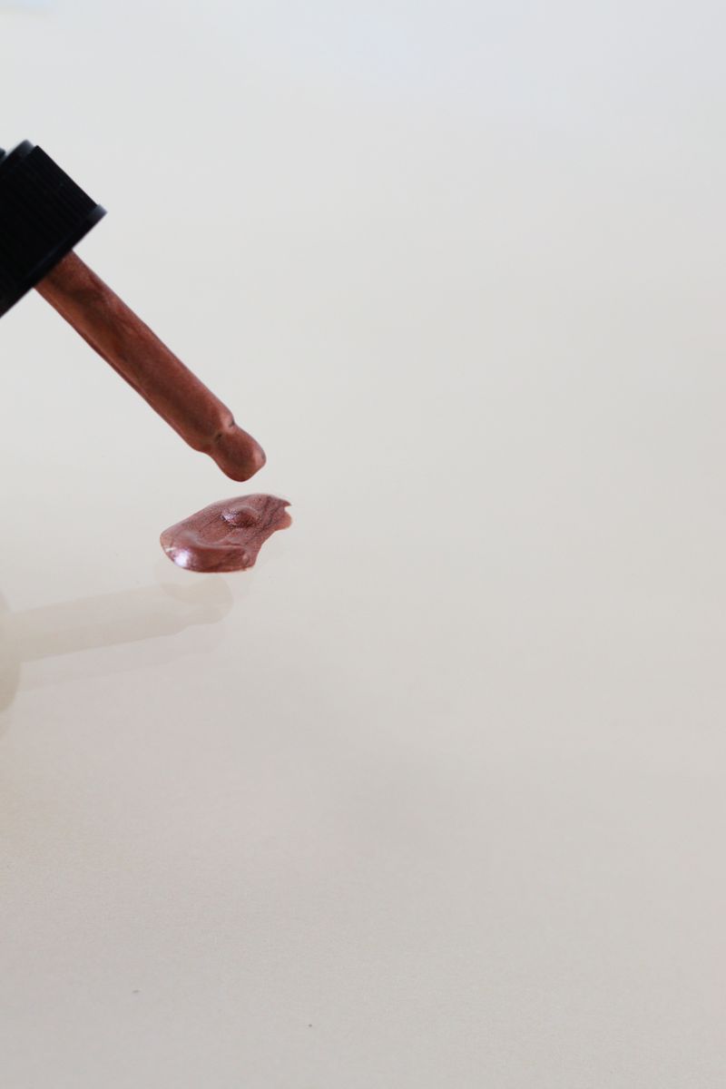 A serum dropper dispensing a tinted drop — the line between skincare and makeup is disappearing