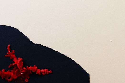 Minimalist image showcasing red crayon shavings on black and white paper background.