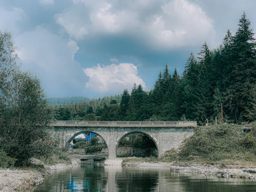 Arched stone bridge over calm river
