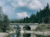 Arched stone bridge over calm river