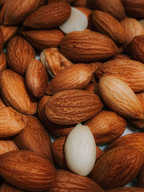 Raw almond nuts heaped on table