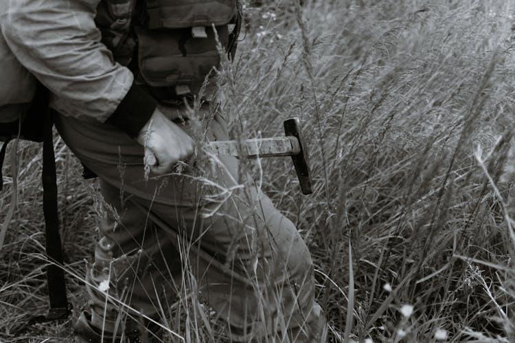 Anonymous Male Geologist With Hammer And Expedition Equipment In Field