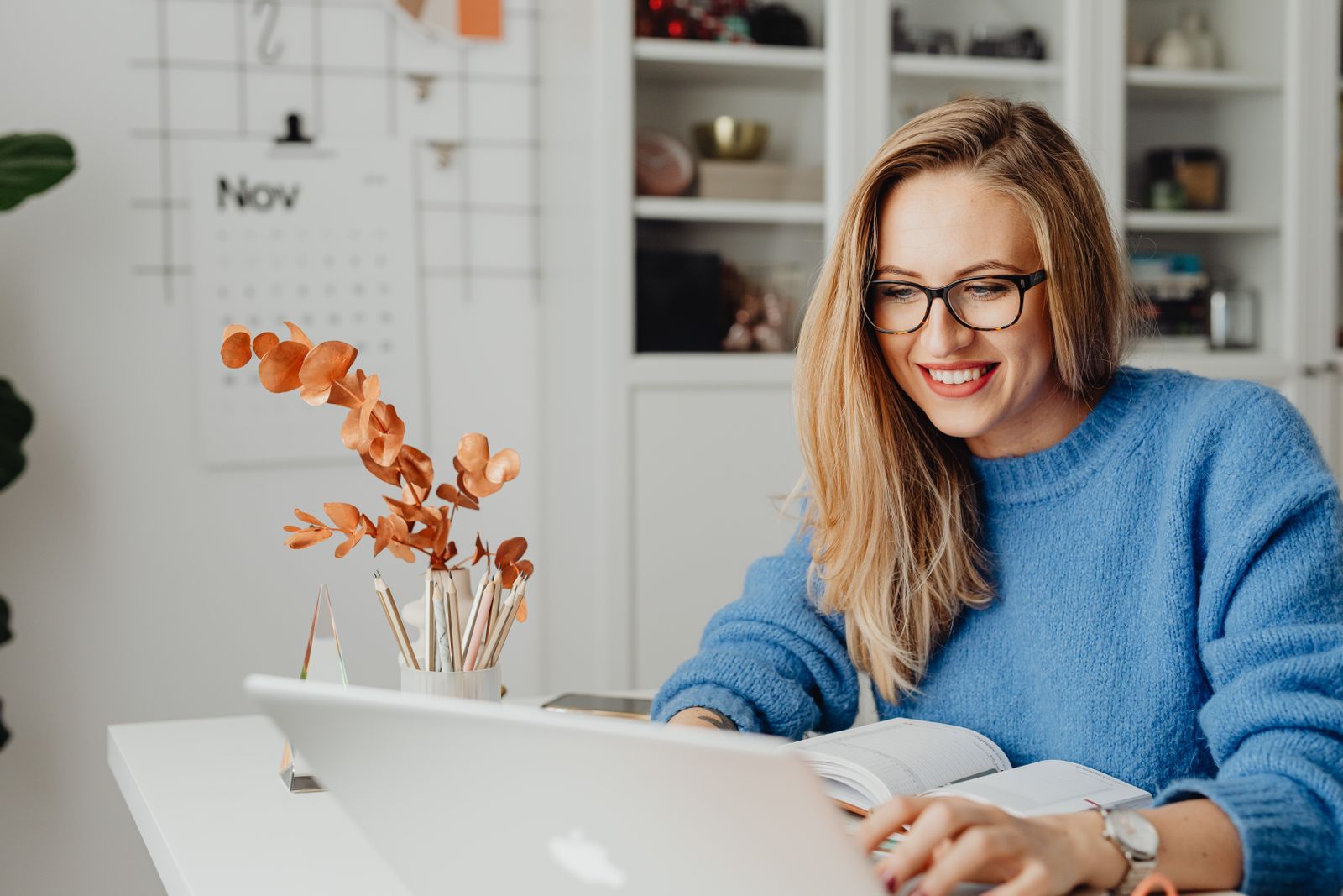 Woman smiling while working on a laptop at home