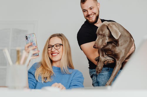 Free Man and Woman Smiling While Looking at a Cellphone Stock Photo