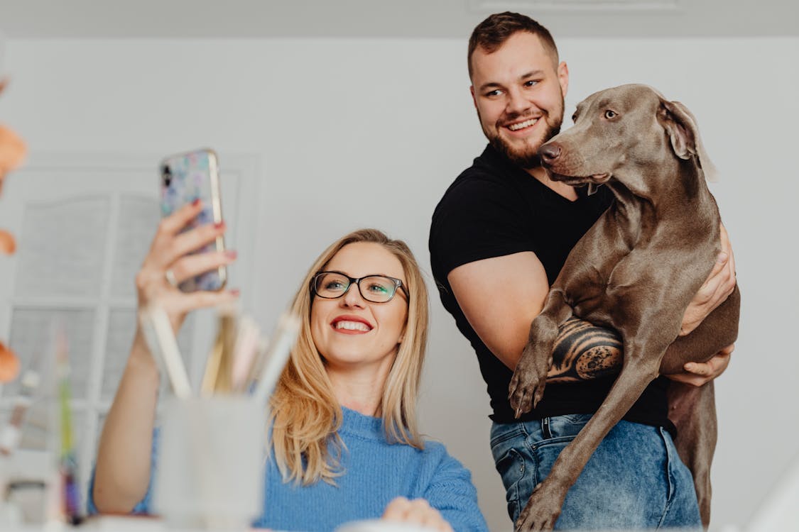 Free Couple with a Dog Taking Selfie Picture Stock Photo