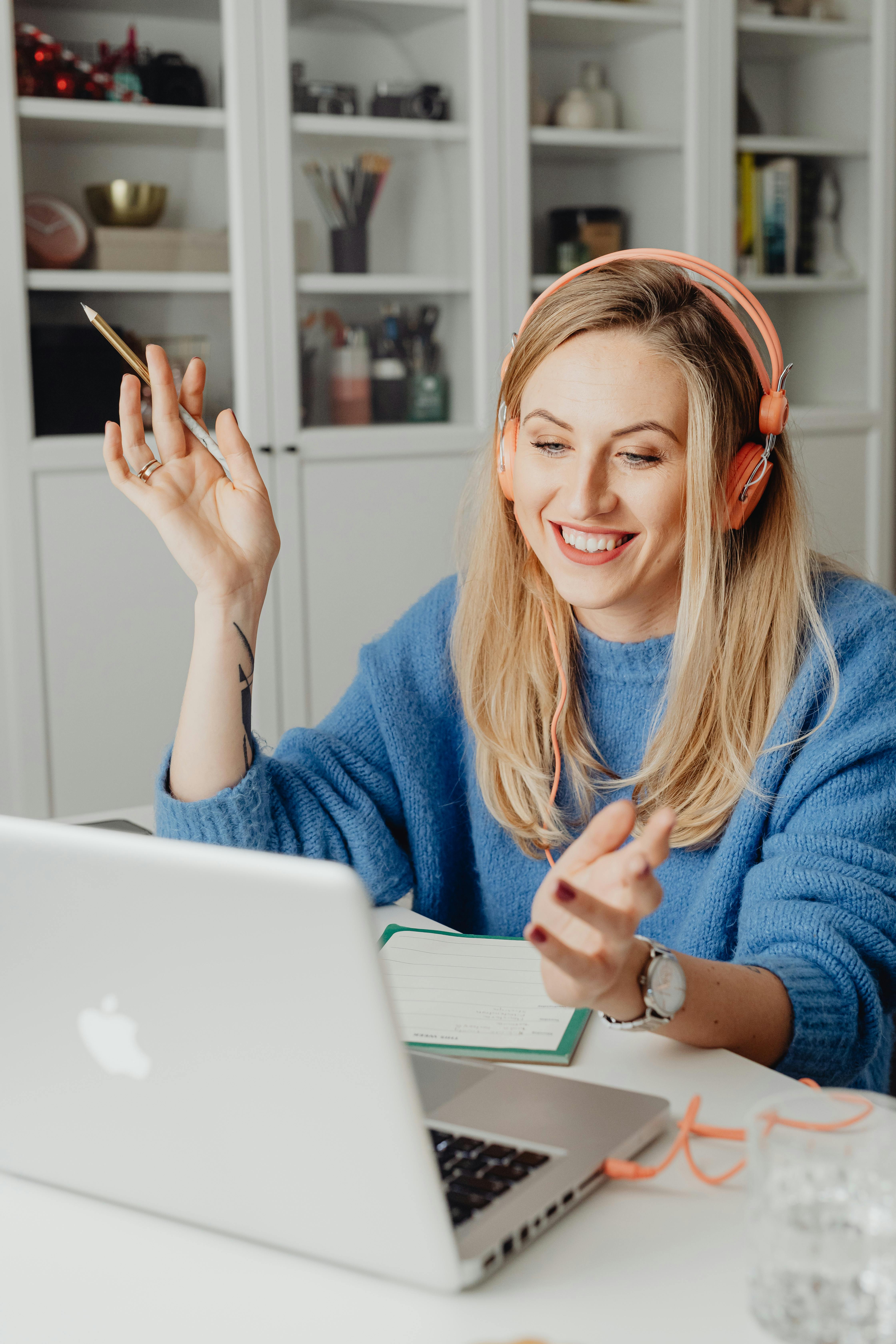 woman in blue sweater using her laptop