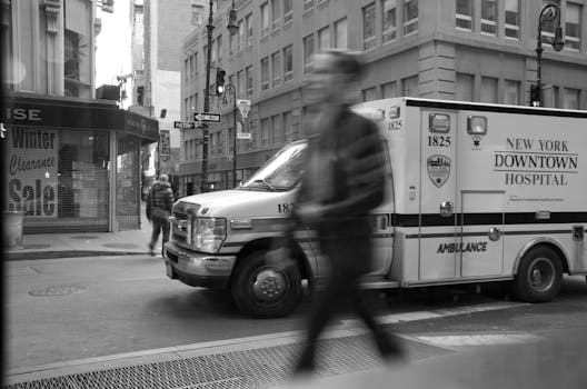 Blurred motion of pedestrians and ambulance in New York City street.
