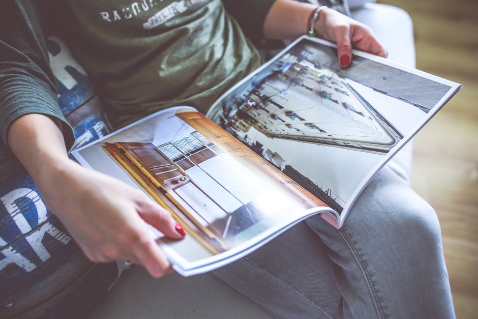 Original Living Magazine Unveils its Spring 2026 Cover with Luxury Fashion Celebration in Boca Raton 2 A person relaxes on a sofa, flipping through an architecture-themed magazine. | BocaVibe