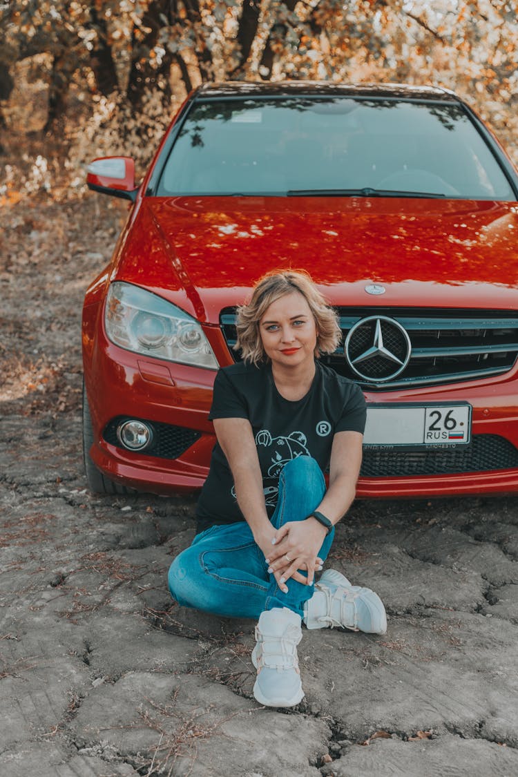 Cheerful Woman Sitting Near Modern Car