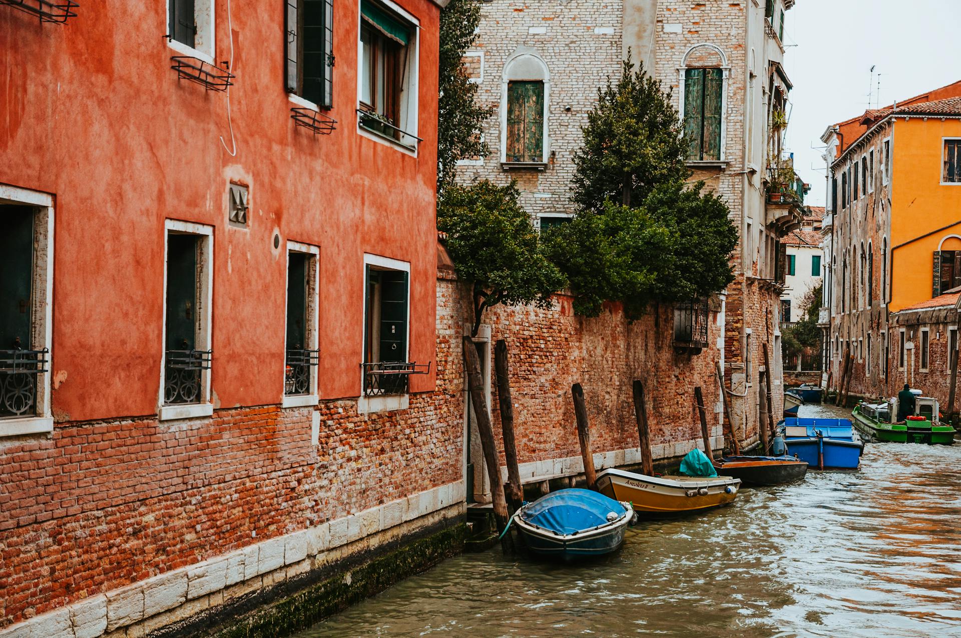 Picturesque view of a Venetian canal with vibrant building facades and moored boats.