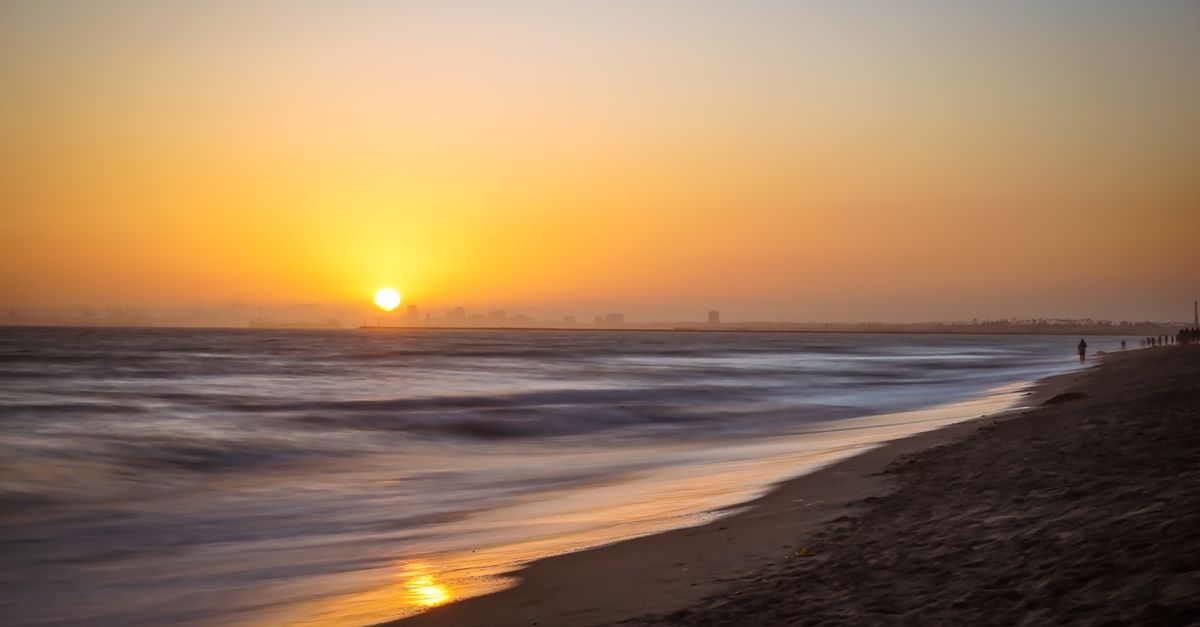 Captivating view of a sunset over Huntington Beach with gentle ocean waves and a serene atmosphere.