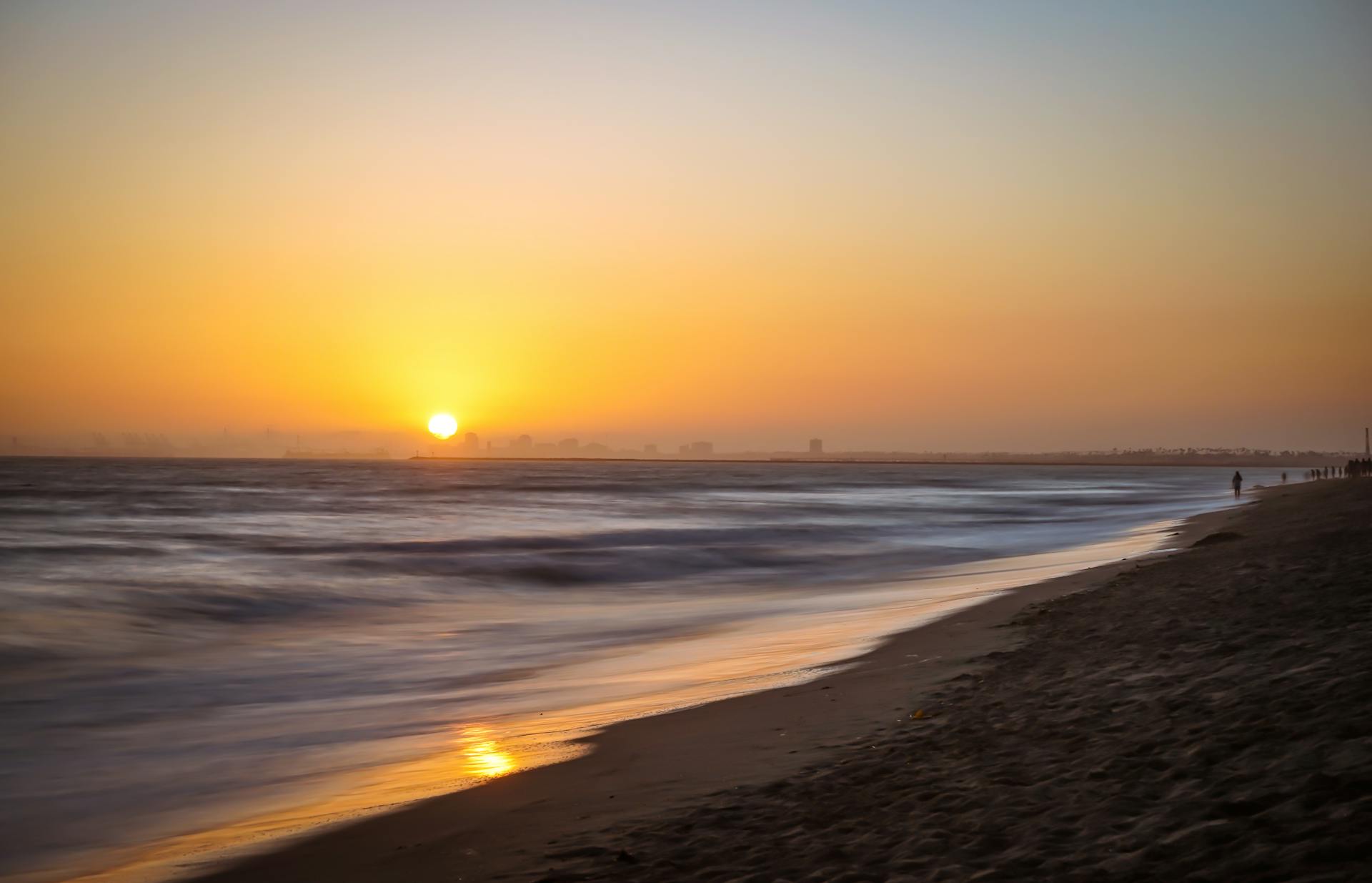 Captivating view of a sunset over Huntington Beach with gentle ocean waves and a serene atmosphere.