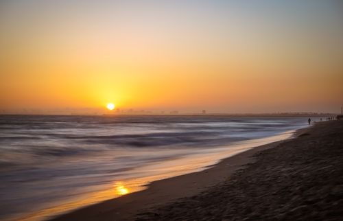 Free Captivating view of a sunset over Huntington Beach with gentle ocean waves and a serene atmosphere. Stock Photo