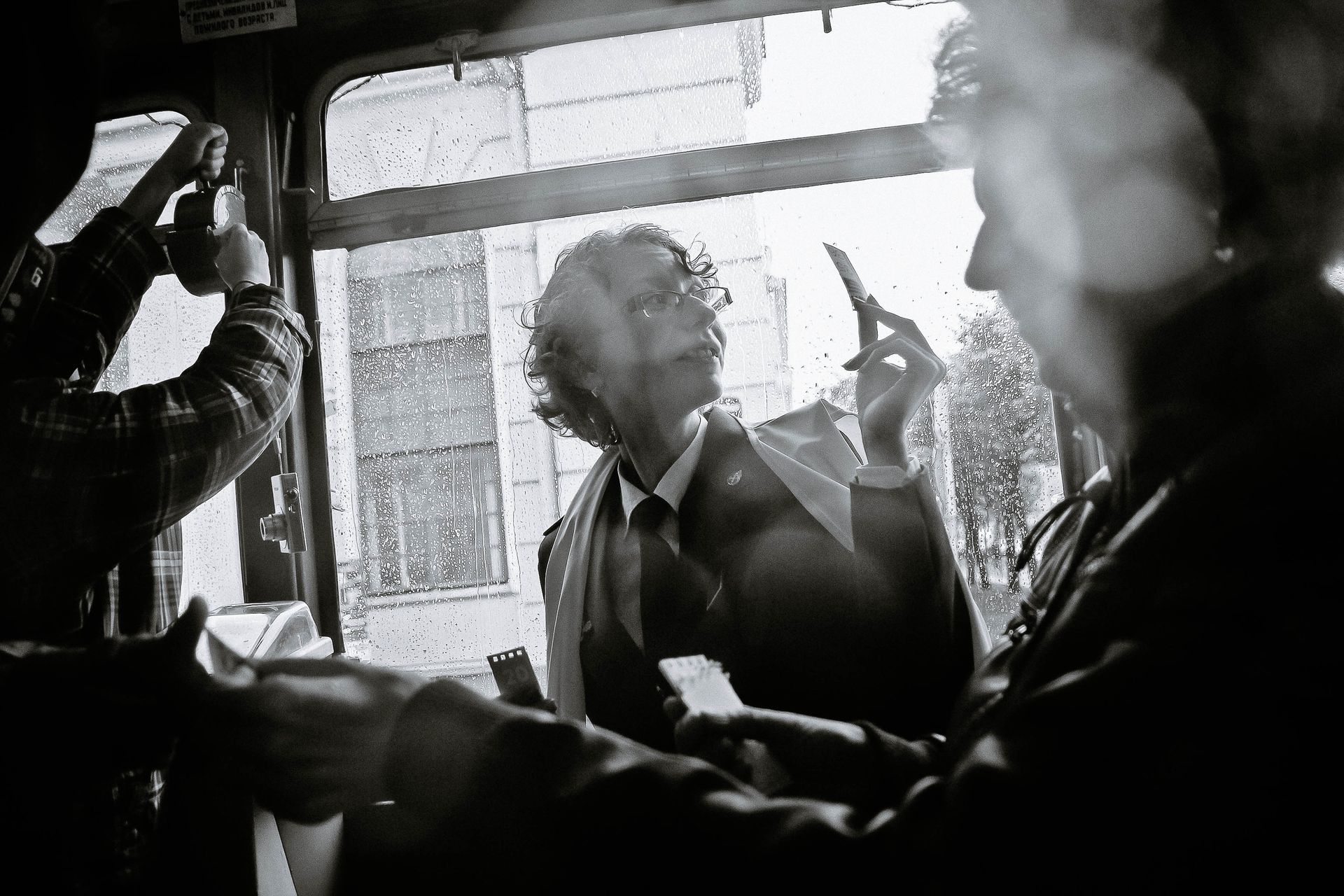 A ticket inspector punching a passenger's ticket aboard a vintage tram