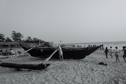 Shabby boat on sandy crowded beach